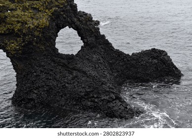 Eroded circular opening in the basalt rock of Gatklettur at Arnarstapi in Iceland