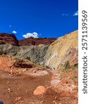 Eroding red rock canyon walls in the desert landscape of Cisco, Utah, set against a vivid blue sky with sparse desert vegetation below.