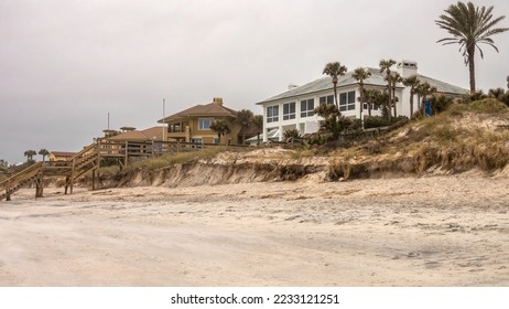 Erosion of dunes, caused by Hurricanes Ian and Nicole in 2022, is evident after cleanup near upscale beach houses along the Atlantic Coast south of Jacksonville, Florida, on a cloudy day in autumn - Shutterstock ID 2233121251