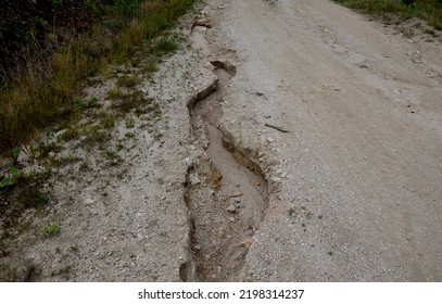 Erosion Grooves After Rains In A Dirt Road. Deep Ground After A Storm. Lack Of Drainage Will Cause Serious Damage To The Surface Of The Bike Path Or The Forest Timber Yard