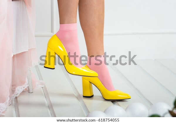 ピンクの靴下と黄色い靴をはいたエロティックな脚 白い背景に若いセクシーな女性の脚 の写真素材 今すぐ編集
