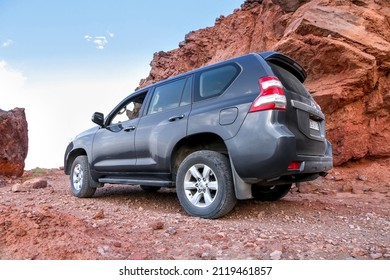 Errachidia, Morocco - September 26, 2019: Black Offroad Car Toyota Land Cruiser Prado 150 Near The Red Rocks.