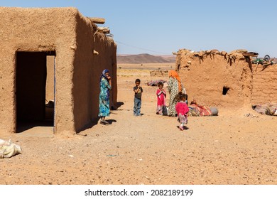 Errachidia Province, Morocco - October 15, 2015: Berber huts in the Sahara Desert. Berber women and children stand outside the house.