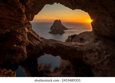 Es Vedra islet view through the rock holes of a cave at sunset, Sant Josep de Sa Talaia, Ibiza, Balearic Islands, Spain - Powered by Shutterstock