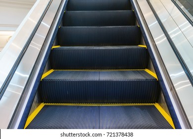 Escalator In Community Mall, Shopping Center. Moving Up Staircase. Electric Escalator. Close Up To Escalators. Close Up Floor Platform. Yellow Bands. Metal Line Steel. Yellow Gray Steel Line.