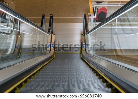 Escalator in Community Mall, Shopping Center or Department Store. Moving Staircase. Neon Light, Modern Escalator