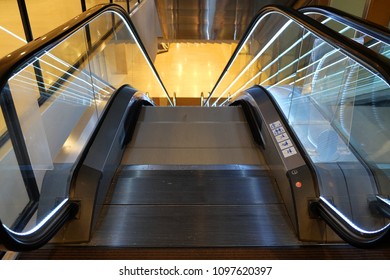Escalator with handrail going down direction to the basement in a building