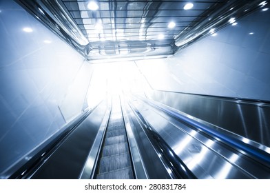 Escalator and light at end of tunnel