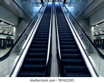 Escalator at metro station with no people. Looking up at an escalator, shinny metal and reflective glass.  Clean and modern design. In situ concrete columns. Instagram photo filter added. - Powered by Shutterstock