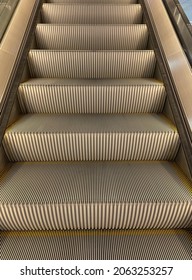An escalator is a moving staircase which carries people between floors of a building or structure