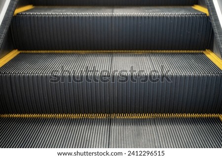 An escalator standing panel with caution line, the electric equipment device for transportation. Close-up and selective focus.