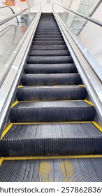 escalator is a moving staircase consisting of an endlessly circulating belt of steps driven by a motor, conveying people between the floors of a public building.