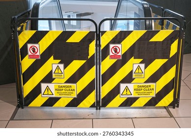 Escalator under maintenance danger keep clear sign in shopping mall