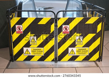 Escalator under maintenance danger keep clear sign in shopping mall