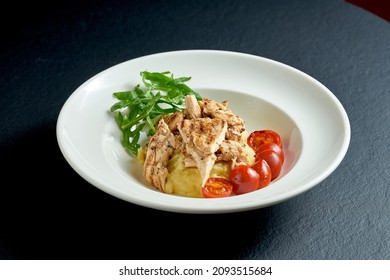 Escalope with mashed potatoes on white plate on black background