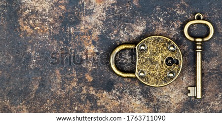 Escape room game concept. Web banner of a vintage gold key and locked padlock on a rusty metal background.
