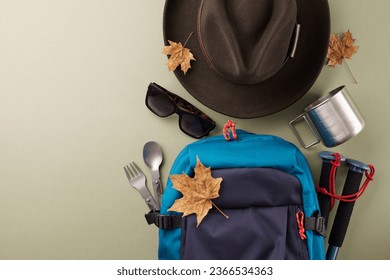 Escaping into the natural world for a weekend outing. Top view photo of blue rucksack, metal utensils, hat, trekking sticks, sunglasses, autumn leaves on green background with promo space - Shutterstock ID 2366534363