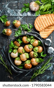 "Escargots de Bourgogne" - baked snails with garlic, butter and basil. French traditional food. Top view. Free space for your text.