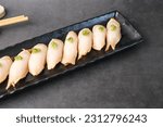  Escolar, oilfish, butterfish nigiri, or sashimi with fresh wasabi on a black plate. Traditional Japanese food  