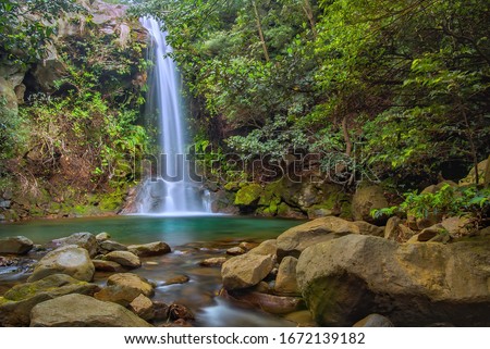 Escondida waterfall and pool surrounded by vegetation in a small canyon at rincon de la vieja national park, costa rica