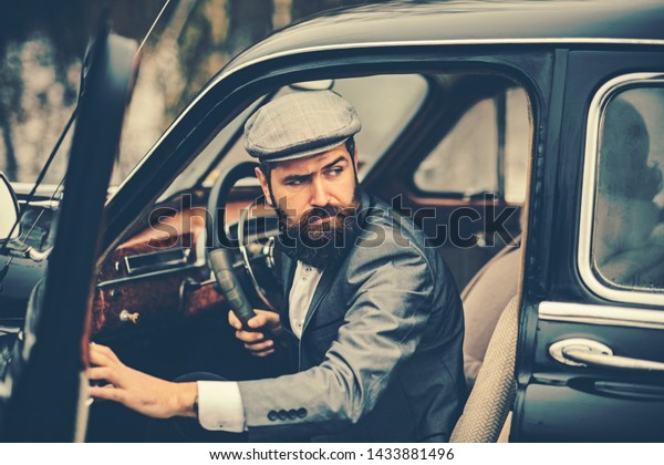 Escort man or security guard. escort service of\
bearded man in retro car