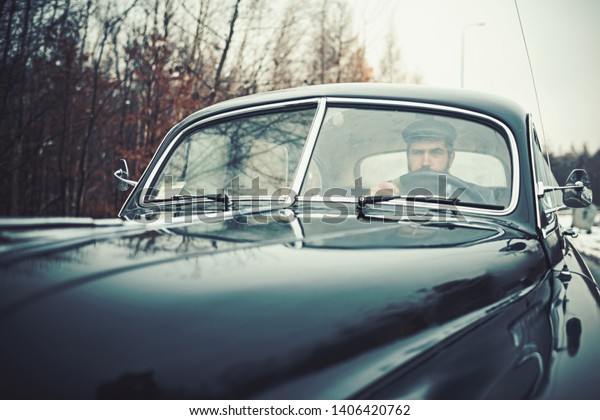 Escort man or\
security guard. Travel and business trip or hitch hiking. Bearded\
man in car. Call boy in vintage auto. Retro collection car and auto\
repair by mechanic\
driver.
