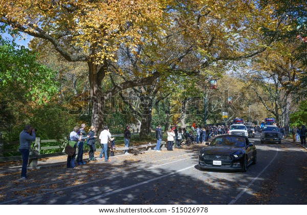 Escort vehicles\
before female frontrunner driving by the crowd of spectators in\
Central Park before 25 mile marker - November 6, 2016, East Drive,\
New York City, NY, USA