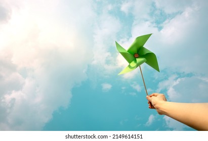 ESG and Clean Energy Concept. Hand Raise up a Wind Turbine Paper into the Sky. Decrease Carbon and Produce a Green Power. World Earth Day, Sustainable Resources, Environmental Care