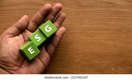ESG concept of environmental, social and governance. Hand holding green cube written with letter E, S and G. - Shutterstock ID 2217431107