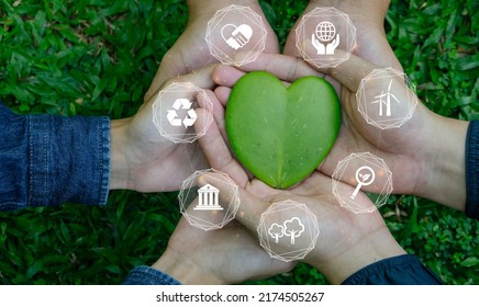 ESG Concept Of Environmental, Social And Governance.Group Of People Holding Heart Shaped Leaves With ESG Icon.