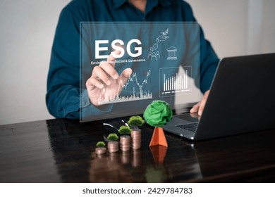 E.S.G. Environment, Society and Governance. Illustration with coins and paper trees. Concept. Businessman analyzes environmental investment graph. For the long-term sustainability of the company. - Powered by Shutterstock