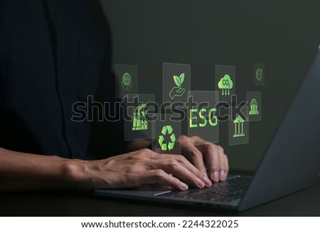 ESG environmental social governance investment business concept. Businessman use a computer to analyze ESG data. icons pop up on virtual screen in business sustainability investment strategy concept.