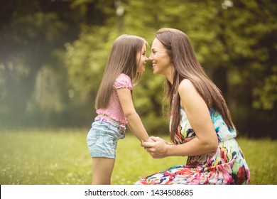 Eskimo Kiss. Mother And Daughter In Nature.