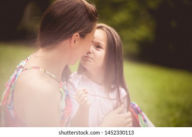 Eskimo Kiss. Mother And Daughter In Nature.