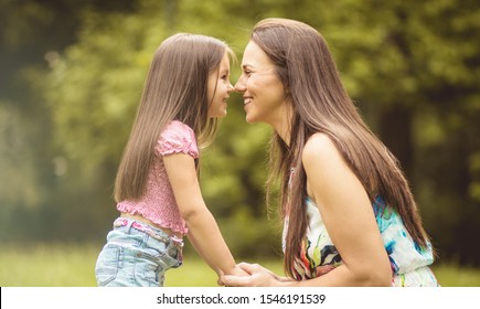 Eskimo Kiss. Mother And Daughter In Nature.