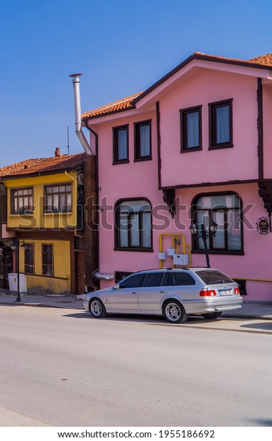 Eskisehir, Turkey - March 8, 2021 - vertical\
street photography of a BMW 5 series and traditional colorful\
Ottoman houses in the Odunpazari\
neighborhood