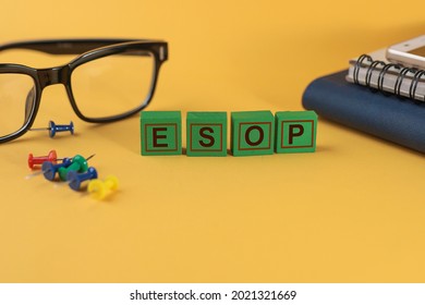 ESOP Or Employee Stock Option Program Word On Green Wooden Blocks On The Yellow Background.