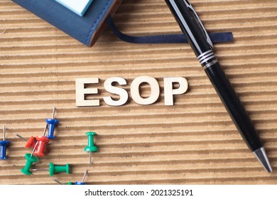 ESOP or Employee Stock Ownership Plan letterings with pen, pins and notebook. Noise is visible due to the texture of the subjects