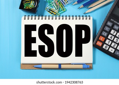 ESOP. Employee Stock Ownership Program. TEXT ON WHITE NOTEBOOK PAPER on blue background near calculator