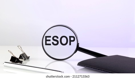 ESOP text concept. Magnifier glass with text with notebook and pen,business concept