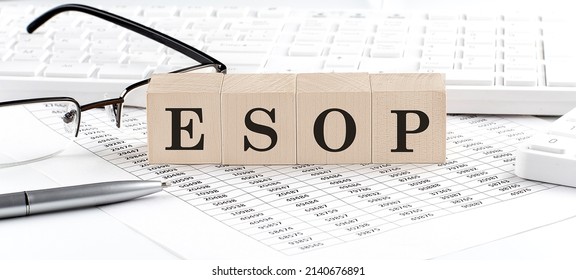 ESOP written on a wooden cube with keyboard , calculator, chart,glasses.Business concept