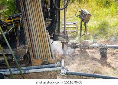 Espoo, FINLAND - JULY 3, 2019: Geothermal Heat Pump Installation In Eco Friendly Apartment House. Drilling Rig In Yard. Worker In Hard Hat Drilling A Borehole For Geothermal Heating System.  