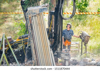 Espoo, FINLAND - JULY 3, 2019: Geothermal Heat Pump Installation In Eco Friendly Apartment House. Drilling Rig In Yard. Worker In Hard Hat Drilling A Borehole For Geothermal Heating System.  