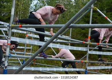 Espoo, Finland - September 14, 2019: Extreme Run Is A Fun Obstacle Race. Female Runners In Fancy Dress Costumes Climb On An Obstacle On The Forest Track. Photographed In Leppävaara Sports Park.