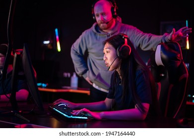 Esports Team Training Camp In Computer Club With Coach, Caucasian Guy And Asian Girl