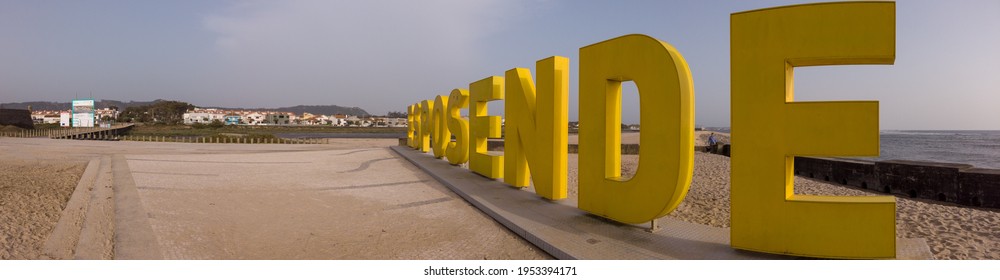 Esposende, Portugal - April 3, 2021: Panoramic Shot Of The Big Yellow Block Letters Spelling Esposende Offer Tourists A Selfie-photo Opportunity With A Beautiful Blue Sea In The Background.