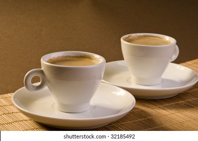 Espresso coffee cups objects over brown colored background