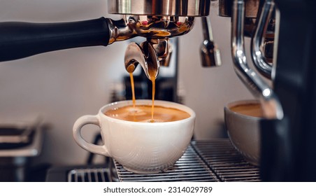 Espresso coffee extraction from a professional coffee machine with a bottomless filter, Close-up of a coffee drop  from the coffee machine - Powered by Shutterstock