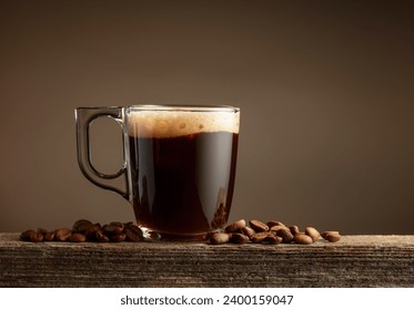 Espresso coffee glass cup on a brown background. Coffee cup and roasted coffee beans on a old wooden board. Copy space. - Powered by Shutterstock