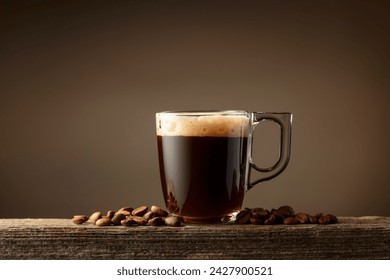 Espresso coffee glass cup on a brown background. Coffee cup and roasted coffee beans on a old wooden board. Copy space. - Powered by Shutterstock